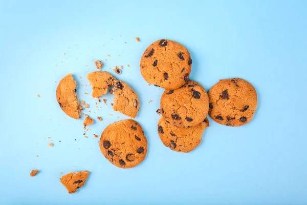 Gustosi biscotti con gocce di cioccolato su sfondo di colore — Foto Stock