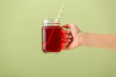 Kadın el renkli arka plan üzerinde taze nar suyu mason kavanoz tutan