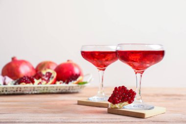 Glasses of fresh pomegranate juice on table clipart