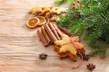 Ahşap masa üzerinde lezzetli Noel kurabiye, tarçın çubukları ve köknar dalı