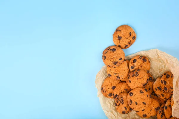 Gustosi biscotti con gocce di cioccolato su sfondo di colore — Foto Stock