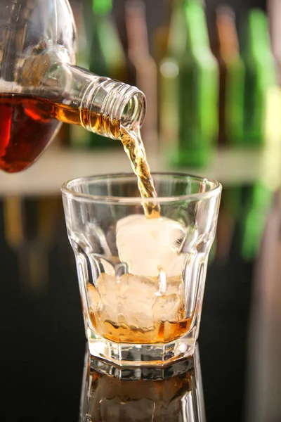 Hälla whisky i glas på bordet — Stockfoto