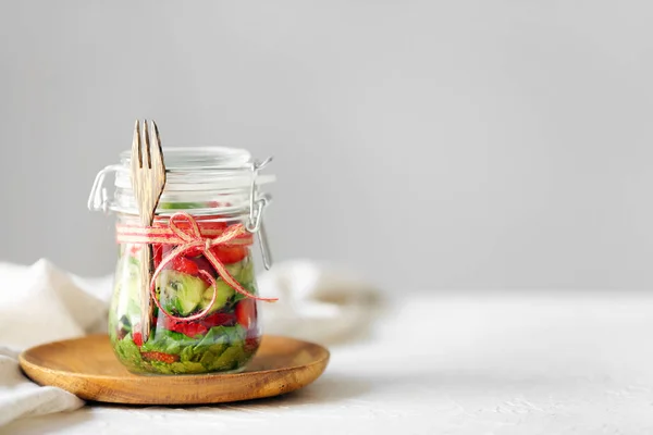 Glass jar with fresh tasty salad on table — Stock Photo, Image