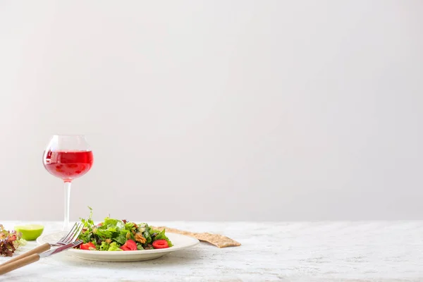 Plate with fresh tasty salad and glass of drink on table — Stock Photo, Image