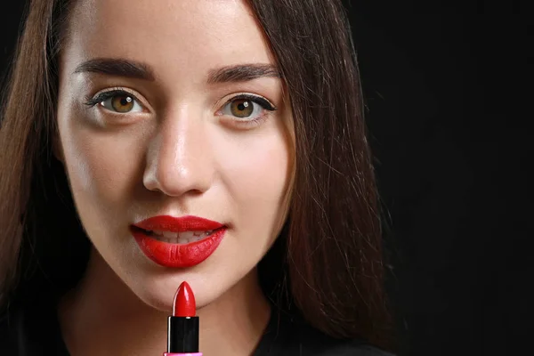 Beautiful young woman with bright lipstick on dark background — Stock Photo, Image