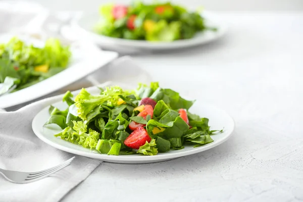 Placas com salada saborosa fresca na mesa leve — Fotografia de Stock