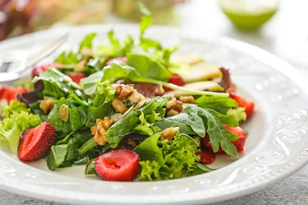 Plattan med färska välsmakande sallad på bordet, närbild — Stockfoto