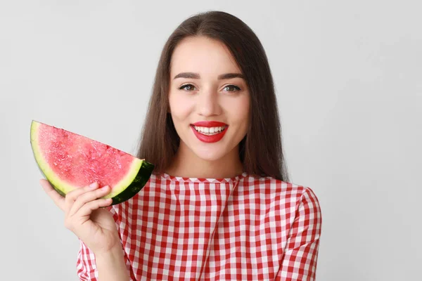 Beautiful young woman with slice of fresh watermelon on light background — Stock Photo, Image