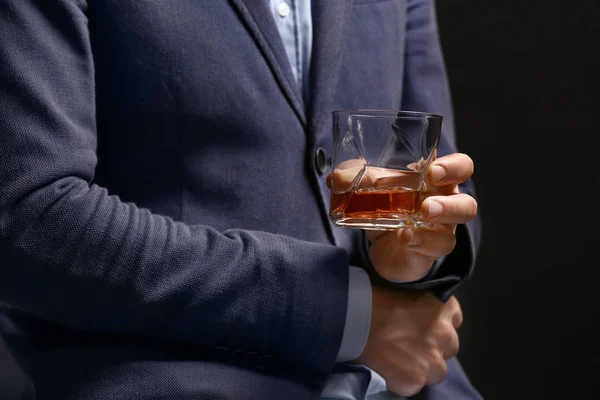 Affärsman med glas whisky på mörk bakgrund, närbild — Stockfoto