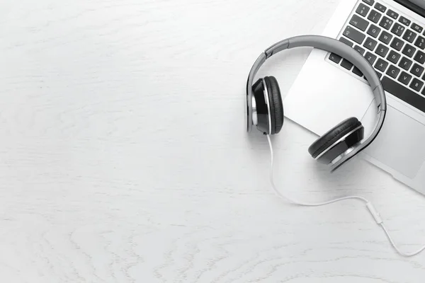 Modern headphones and laptop on white background