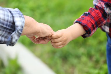 Büyükanne açık havada el ele tutuşan sevimli küçük kız