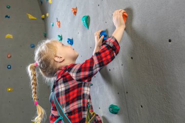 Küçük kız spor salonunda duvar tırmanma