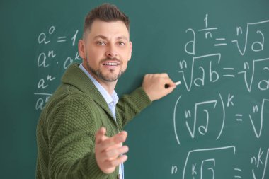 Yakışıklı matematik öğretmeni sınıfta tahtaya yazma