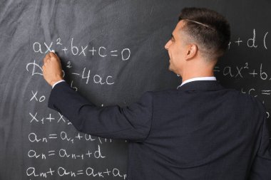 Yakışıklı matematik öğretmeni sınıfta tahtaya yazma