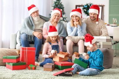 Aileleri ile küçük çocuklar evde Noel hediyeleri açılış