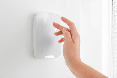 Modern güvenlik sistemi paneline kod giren kadın