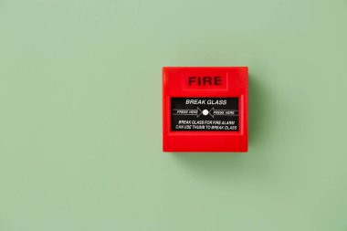 Modern manual call point of fire alarm system on color wall clipart