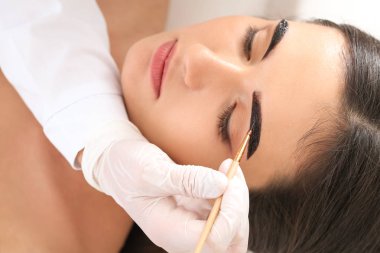 Güzellik salonunda kaş düzeltme ameliyatı olan genç bir kadın.