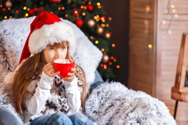 Küçük kız Noel arifesinde evde sıcak çikolata içme