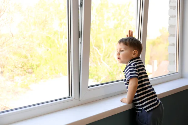 Маленький мальчик с аутизмом возле окна дома — стоковое фото