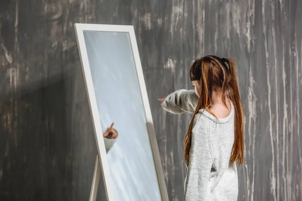 Bambina con disturbo autistico guardando nello specchio su sfondo grunge — Foto Stock