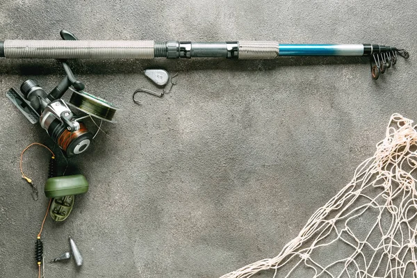 Рыболовные снасти, сетки и аксессуары на сером фоне — стоковое фото