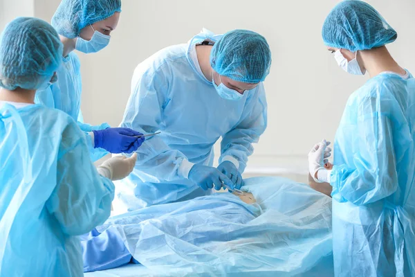 Пластические хирурги оперируют пациента в клинике — стоковое фото