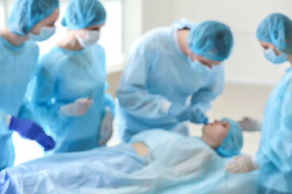 Klinikte hasta yı çalıştıran plastik cerrahlar, bulanık görünüm — Stok fotoğraf