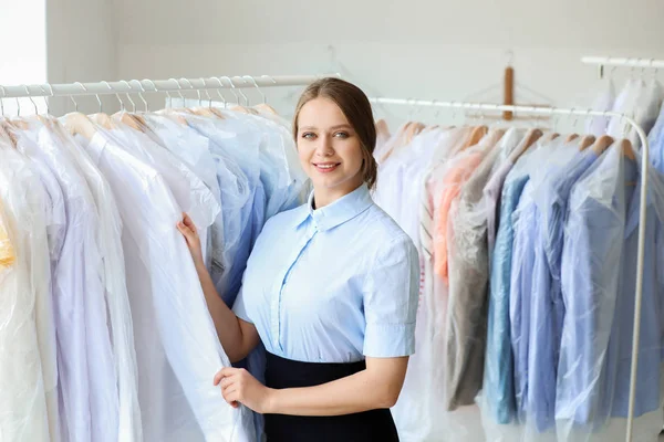 Travailleur de nettoyage à sec moderne près de rack avec des vêtements — Photo