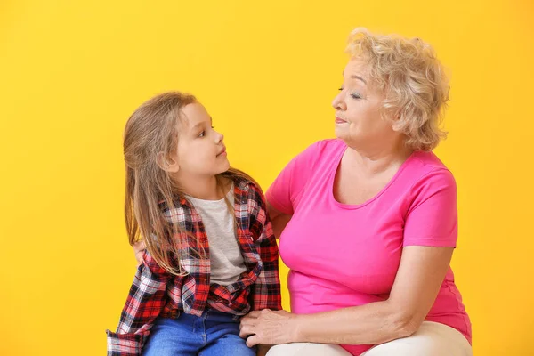 Linda niña con abuela en el fondo de color —  Fotos de Stock