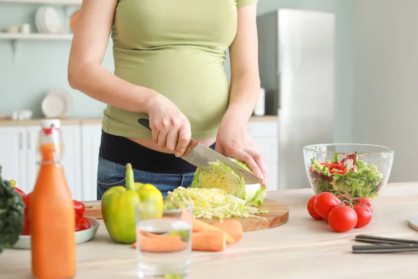 Young pregnant woman cooking in kitchen — Stock Photo, Image