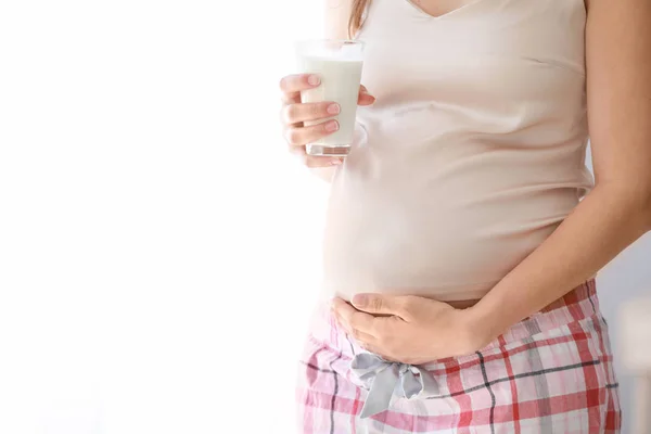 Beautiful pregnant woman with glass of milk near window — Stock Photo, Image