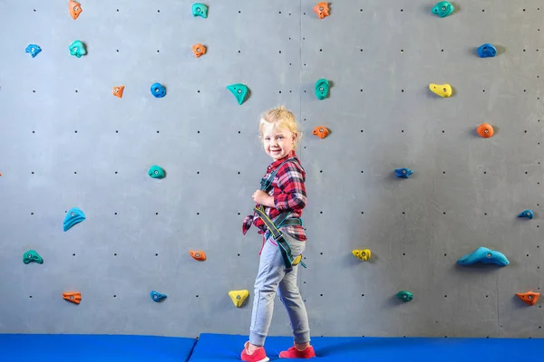 Mała dziewczynka w pobliżu ściany wspinaczkowej w siłowni — Zdjęcie stockowe