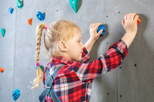 Mała dziewczynka wspinaczkowa ściana w siłowni — Zdjęcie stockowe
