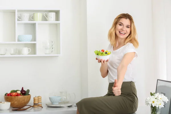 Woman eating healthy vegetable salad in kitchen — Stock Photo, Image