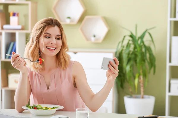 オフィスで健康的な野菜サラダを食べながら自分撮りをする女性 — ストック写真