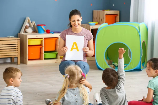 Crianças pequenas bonitos aprendendo letras no jardim de infância — Fotografia de Stock