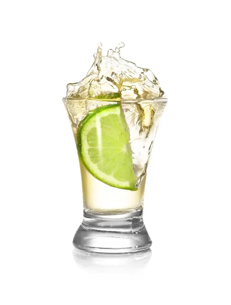 Dropping of lime into glass with tasty tequila on light background — Stock Photo, Image