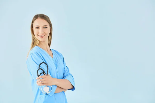 Female nurse with stethoscope on color background — Stock Photo, Image