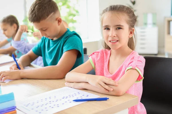 Pupils passing school test in classroom