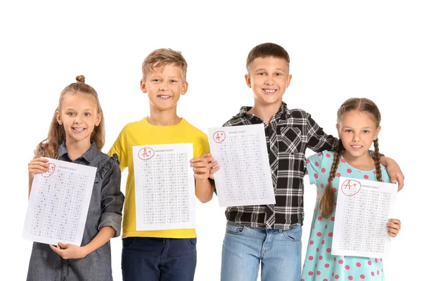 Crianças felizes com folhas de resposta para teste escolar em fundo branco — Fotografia de Stock