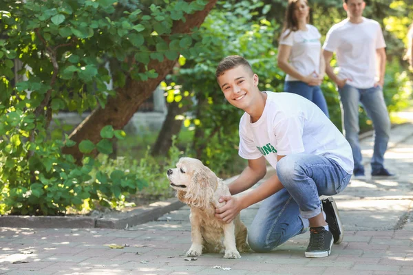 Freiwilliger Teenager mit süßem Hund im Freien — Stockfoto