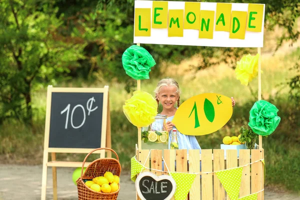 Linda niña vendiendo limonada en el parque — Foto de Stock