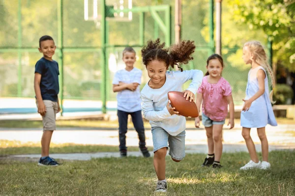 Cute little children playing with rugby ball in park — Stock Photo, Image