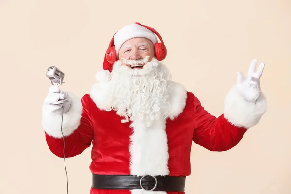 Retrato de Santa Claus con micrófono escuchando música sobre fondo claro —  Fotos de Stock