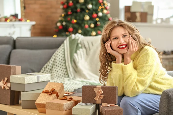 Glückliche junge Frau mit Weihnachtsgeschenken zu Hause — Stockfoto