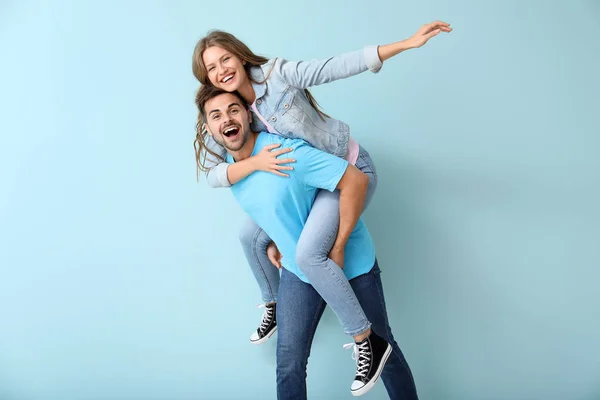 Feliz joven pareja divirtiéndose en el fondo de color —  Fotos de Stock