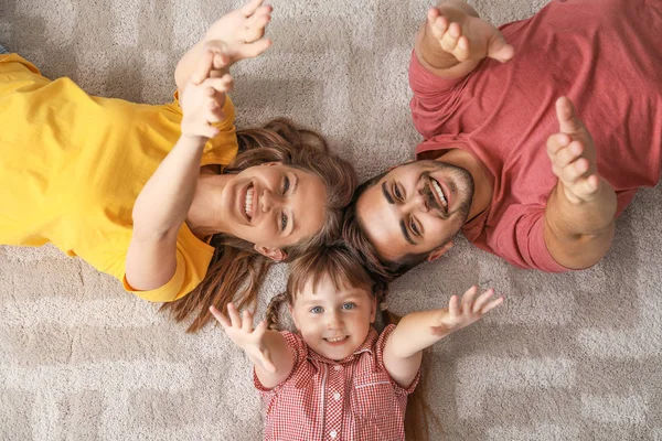 Portret van Happy Young familie liggend op tapijt thuis — Stockfoto