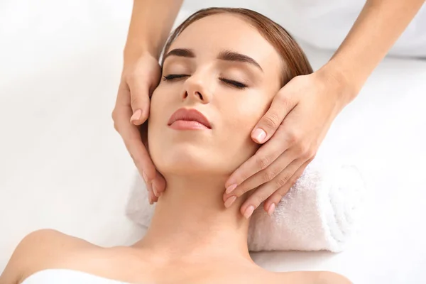 Mujer joven teniendo masaje facial en salón de belleza —  Fotos de Stock