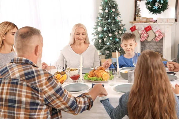 Семья молится перед рождественским ужином дома — стоковое фото